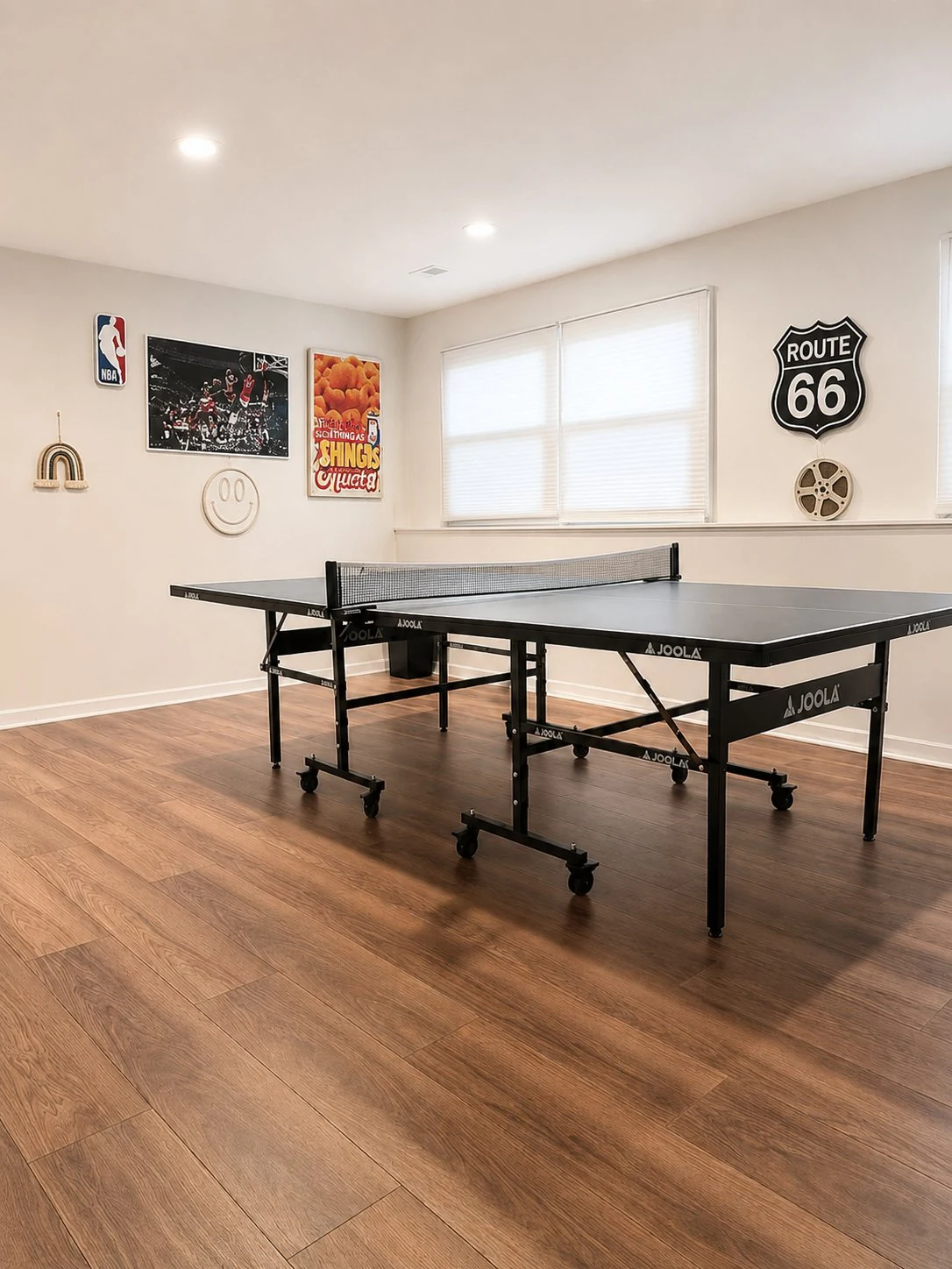 Lower-level family and game room with wood-look plank flooring, a full-size JOOLA table tennis table, a dartboard, recessed lighting, and fun wall decor including a Route 66 sign.