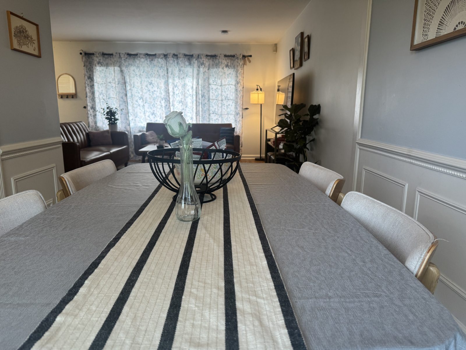 Newly remodeled upper-level full bathroom with a white shaker-style double vanity, marble countertop, matte black hardware, large framed mirror, gray plank tile flooring, and walk-in shower.